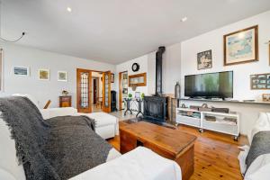 uma sala de estar com mobiliário branco e uma televisão de ecrã plano em Hauzify I Villa del Castell em Altafulla
