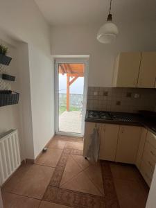eine Küche mit Blick auf eine Tür zu einer Terrasse in der Unterkunft Luca Vendégház 1. apartman in Sárvár
