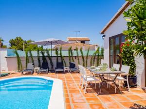 d'une terrasse avec une table et des chaises à côté de la piscine. dans l'établissement Cubo's Finca La Graciosa, à Alhaurín de la Torre