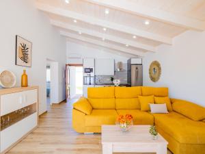 - un salon avec un canapé jaune et une table dans l'établissement Cubo's Finca La Graciosa, à Alhaurín de la Torre