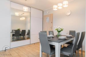 - une salle à manger avec une table et des chaises dans l'établissement Flatbook Apartamenty - Jantar Park I, à Jantar