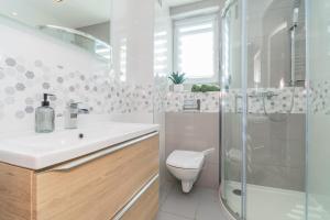a bathroom with a toilet and a sink and a shower at Flatbook Apartamenty - Jantar Park I in Jantar