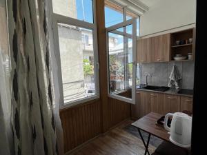 uma cozinha com uma grande janela e uma porta de madeira em beautiful apartment near opera in t'bilisi center em Tbilisi