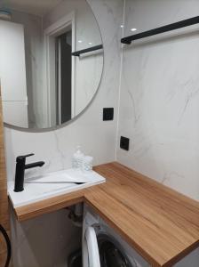 a bathroom with a sink and a mirror and a washing machine at Blue Mare Hebe Apartament in Łukęcin