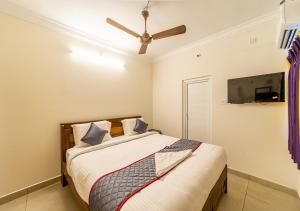 a bedroom with a bed and a ceiling fan at Yellow Residency in Puducherry