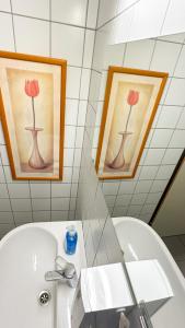 a bathroom with two paintings of flowers on the wall at Mali Schachmuseum in Klagenfurt