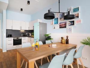 a kitchen and dining room with a wooden table and chairs at Seebrücke Heringsdorf - Appartement mit 2 Schlafzimmern und Balkon S6 in Heringsdorf