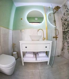 a bathroom with a sink and a toilet and a mirror at Suit Rabando Uzungöl in Uzungöl