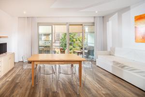 a dining room with a table and a couch at Monaco Apartments in Lignano Sabbiadoro