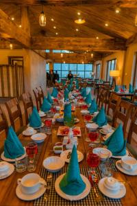 een lange tafel met blauwe servetten en borden erop bij Dynasty Hotel Skardu in Skardu