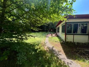 una casa seduta sull'erba accanto a un edificio di Elfenhütte Ferienhaus Eifel a Rott