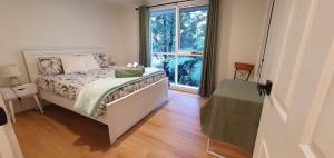 1 dormitorio con cama y ventana grande en Grey Gum Getaway en Belgrave