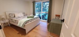 a bedroom with a bed and a large window at Grey Gum Getaway in Belgrave