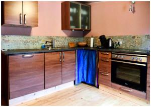 uma cozinha com armários de madeira, um lavatório e um fogão em Elfenhütte Ferienhaus Eifel em Rott