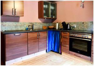 a kitchen with wooden cabinets and a sink and a stove at Elfenhütte Ferienhaus Eifel in Rott