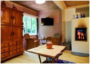 a living room with a table and a fireplace at Elfenhütte Ferienhaus Eifel in Rott