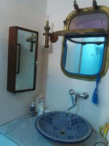 Tipica casa marinara carlofortina في كارلوفورتي: حوض الحمام مع مرآة ومغسلة
