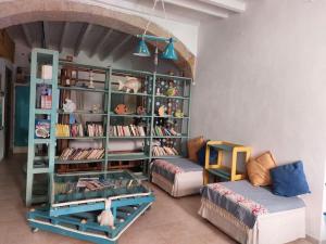 ein Wohnzimmer mit Bücherregal und Sofa in der Unterkunft Tipica casa marinara carlofortina in Carloforte