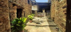 a courtyard in an old stone building with potted plants at CASA GRANDE VILAR in Vilar
