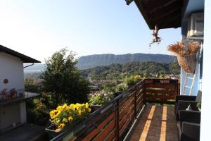 un balcón con flores y vistas a las montañas en B&B All'Antica Fonte en Forgaria nel Friuli