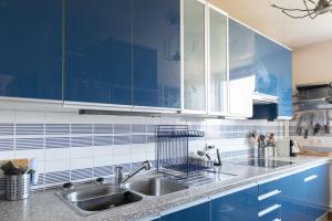 eine Küche mit blauen Schränken und einem Waschbecken in der Unterkunft Bright cocoon with large terrace in Paris