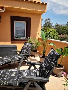 two lounge chairs sitting on a balcony with plants at Marina de Casares Suites in San Luis de Sabinillas