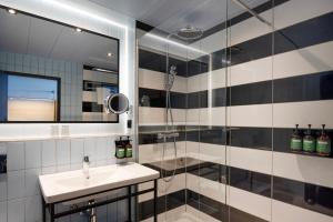 y baño con ducha, lavabo y espejo. en Crowne Plaza Antwerpen, an IHG Hotel en Amberes