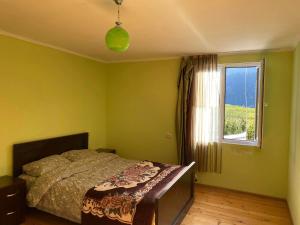 a bedroom with a bed and a window at Bombora in Mestia