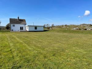 a small white house in a field with a large yard at Hilltop in Holyhead