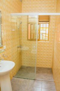 ein Bad mit einer Dusche und einem Waschbecken in der Unterkunft Stunning 6-Bed Apartment in Kigali in Kigali