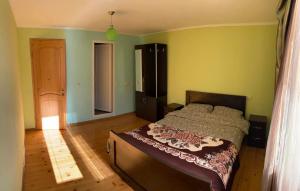a bedroom with a bed in a room with green walls at Bombora in Mestia
