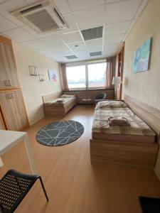 a large room with two beds and a table and chairs at Hostel Hodonín in Hodonín