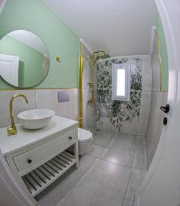 a bathroom with a sink and a toilet and a mirror at Suit Rabando Uzungöl in Uzungöl