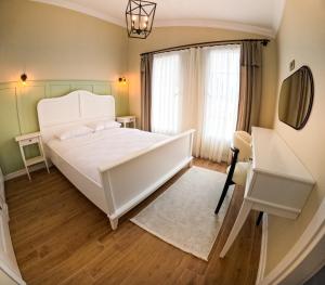 ein Schlafzimmer mit einem weißen Bett und einem Fenster in der Unterkunft Suit Rabando Uzungöl in Uzungöl