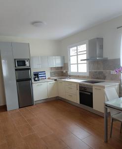 a kitchen with white cabinets and a stove top oven at Mogan Sol in Puerto de Mogán