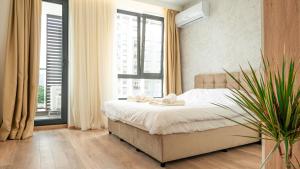 una camera da letto con un letto e una grande finestra di Urban Exec Suite with Free Gym Pass, Full Office Setup and Designated Parking Space a Plovdiv