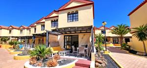 a hotel with tables and chairs in a courtyard at Casa del Sol, Costa Calma in Costa Calma