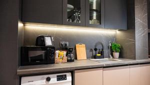 un bancone della cucina con forno a microonde e lavandino di Urban Exec Suite with Free Gym Pass, Full Office Setup and Designated Parking Space a Plovdiv Altre 23 foto