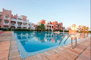 a swimming pool in front of some apartment buildings at Appartement AP2 Résidence Al Waha in Saïdia