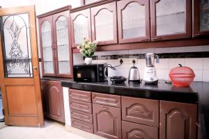 una cucina con armadi in legno e piano di lavoro di Divine India Service Apartment,2Bhk, D-198,SAKET a Nuova Delhi