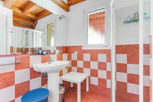 W łazience znajduje się umywalka i lustro. w obiekcie [Piscina Panoramica] - La Casa Volante w mieście Soiano del Lago