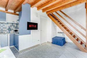 una cucina con soffitti in legno e un cartello con scritto Netflix di [Piscina Panoramica] - La Casa Volante a Soiano del Lago
