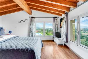 sypialnia z łóżkiem i dużymi oknami w obiekcie [Piscina Panoramica] - La Casa Volante w mieście Soiano del Lago