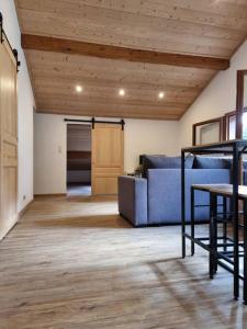 sala de estar con sofá azul y techo de madera en Appartement chaleureux, en Aime La Plagne