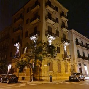 budynek z samochodami zaparkowanymi przed nim w nocy w obiekcie Mama Tita Rooms and Breakfast w mieście Palermo