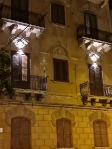 a building with windows and balconies on it at Mama Tita Rooms and Breakfast in Palermo