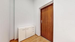 um quarto vazio com uma porta de madeira e um armário em ZIELONY ZAKĄTEK Apartament w centrum przy Agorze em Bytom