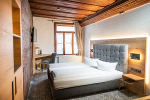 a bedroom with a large white bed and a desk at Ringhotel Schlossberg in Neustadt