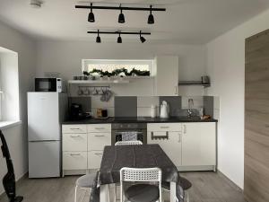 a kitchen with white cabinets and a table in it at Panoramic tranquility on hill of vineyard in Csopak