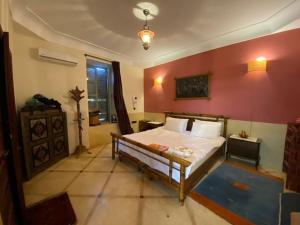 - une chambre avec un lit et un mur rouge dans l'établissement Riad salix d'agafay, à Marrakech